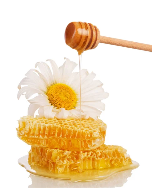 蜂窝状的蜂窝和蜂蜜从一个被白色背景隔开的小勺里流下来 — 图库照片