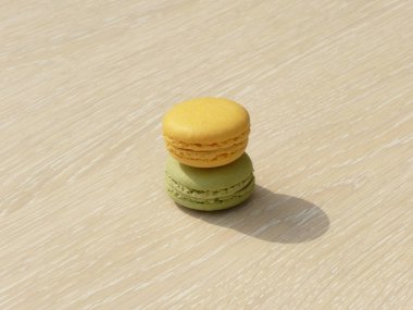 İki macarons bir ahşap zemine yığılmış.
