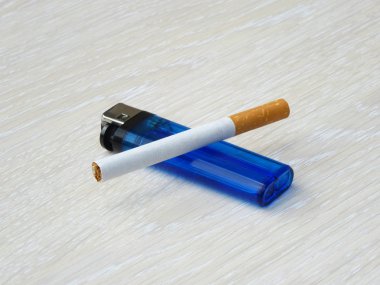 Çakmak ve sigara bir ahşap yüzeye döşeme.