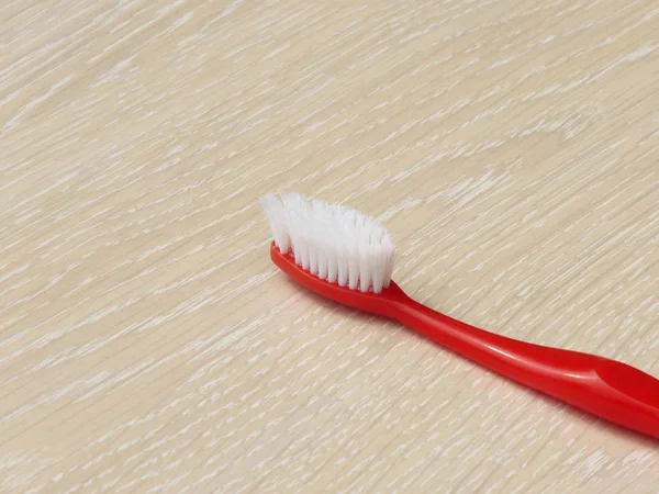 Red Toothbrush On Wooden Surface — Stock Photo, Image