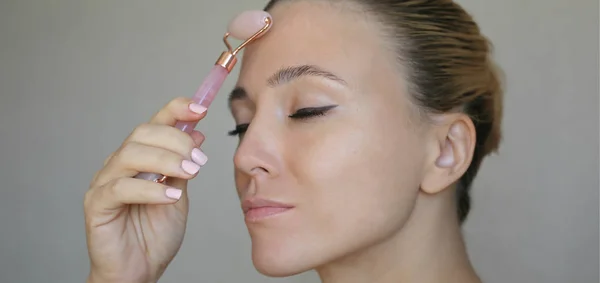 Beautiful Woman Using Pink Rose Quartz Roller Skin Treatment — Stock Photo, Image