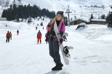Courchevel, Fransa 'da kayak pistinde poz veren kadın snowboardcu..