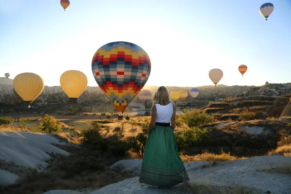 Kapadokya 'da güneşin doğuşunun ve balon uçuşunun keyfini çıkaran güzel mutlu kız gezgin. Özgürlük yaşam tarzı.