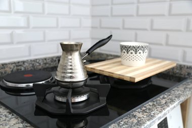 Metal Türk ve kahve fincanı benzin deposunu izole etti. Gaz ocağında bronz kahve demliğinde kahve yapıyor..