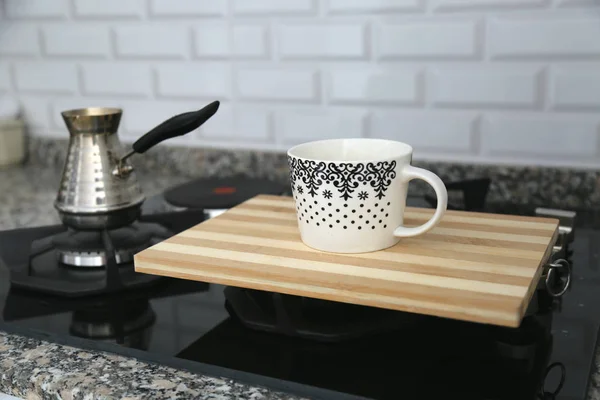 Metal turk and coffee cup isolated the gas steve.Making coffee in bronze coffee pot on gas cooker.