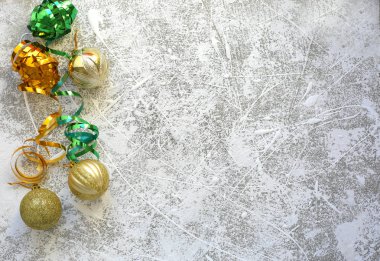 Beyaz karlı arka planda Noel süslemeleri ve altın toplar.