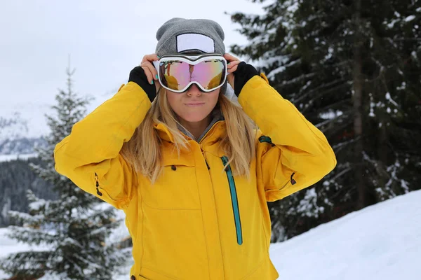 Beautiful ski woman in yellow jacket posing at the slope in Courchevel France.