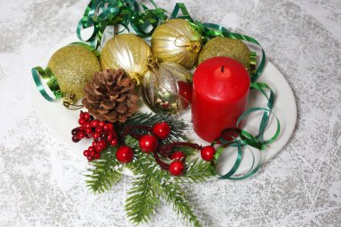 Noel süsleri Kırmızı mumlar ve beyaz arka planda altın toplar.  