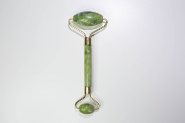 Beyaz arka planda deri gerdirme için yeşil yüz silindiri. Yüz tedavi aracı.