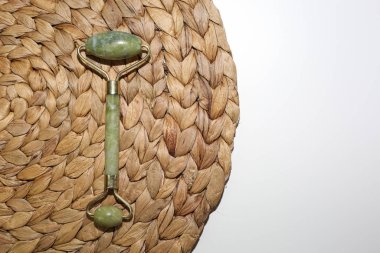 Rat dokuma arka planında cilt gerdirme için yeşil yüz silindiri. Yüz tedavi aracı.