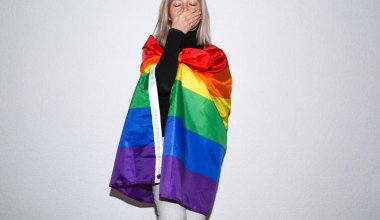 Gökkuşağı bayrağıyla yüzünü gizleyen genç lezbiyen kadın. Yalnız ve üzgün kız.