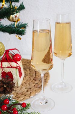 Beyaz masada iki şampanya bardağı. Yeni yıl konsepti.