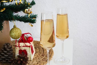 Beyaz masada iki şampanya bardağı. Yeni yıl konsepti.