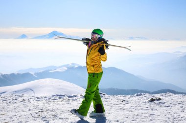  Ski woman holding pair of ski at the top of mountain in Tsaghkadzor ski resort Armenia. clipart
