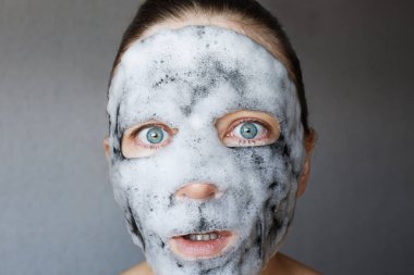 Kabarcık surat maskesi Kore 'nin popüler kozmetik ürünleri. Yüzü köpüklü kömür maskeli kadın. Yüz tedavisi.