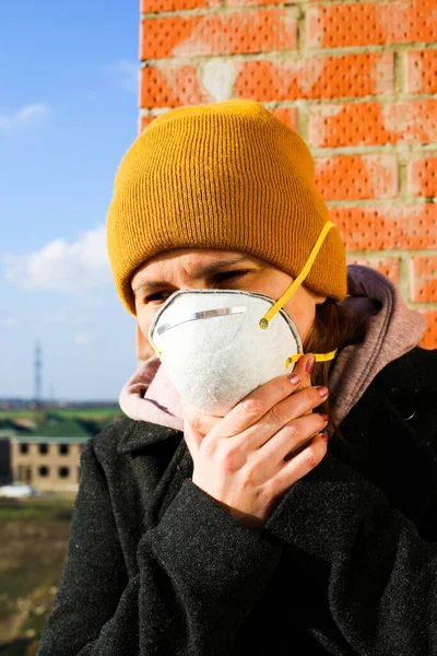 Woman wearing face mask at the street. The concept of the epidemic of the virus. Protect yourself. Vertical photo.