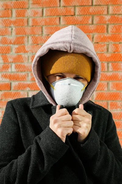 Woman wearing face mask at the street. The concept of the epidemic of the virus. Protect yourself. Vertical photo.