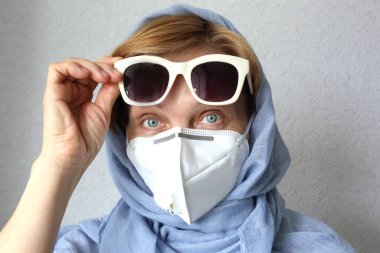 Virüse karşı filtre maske takan olgun bir kadın. Moda tıbbi yüz maskesi.