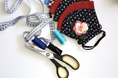 Toz ve virüsün üst görüntüsüne karşı birçok el yapımı pamuk yüz maskesi. Beyaz arka planda Coronavirus önleyici kumaş tekstil maskesi. Süslü yüz maskesi.