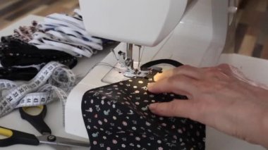 Evde korona virüsüne karşı korunmak için yüz maskeleri dikmek için dikiş makinesi. Covid 19 virüsüne karşı el yapımı koruyucu maske..