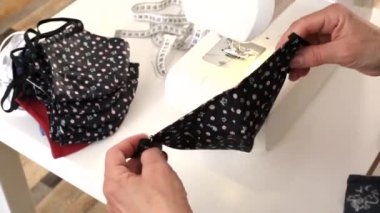 Evde korona virüsüne karşı korunmak için yüz maskeleri dikmek için dikiş makinesi. Covid 19 virüsüne karşı el yapımı koruyucu maske..