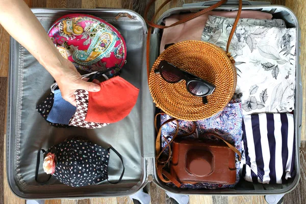 带有女装和棉制面罩的手提包放在木制地板底座上 准备在日冕病毒大流行后出国旅行 旅行概念 预防方法 — 图库照片