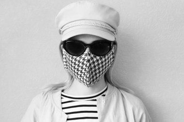 Dekoratif aksesuar olarak el yapımı pamuklu yüz maskesi takan genç bir kadın. Moda endüstrisinde popüler trend. Yeniden kullanılabilir yüz maskesi.