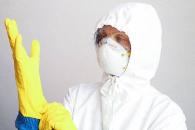 Doktor koruyucu üniforma giyiyor ve yüz maskesi takmış kameraya bakıyor. Corona virüsü 19 konsepti.
