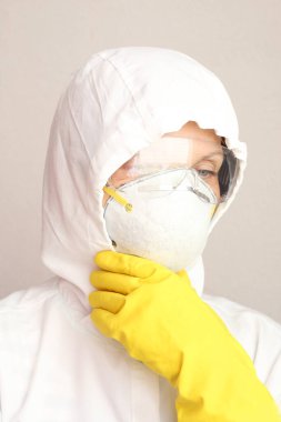 Doktor koruyucu üniforma giyiyor ve yüz maskesi takmış kameraya bakıyor. Corona virüsü 19 konsepti.