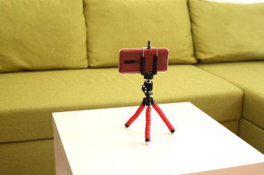 Coronavirus karantinası sırasında video blogu kaydetmek için akıllı telefon ve tripod.