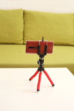 Coronavirus karantinası sırasında video blogu kaydetmek için akıllı telefon ve tripod.