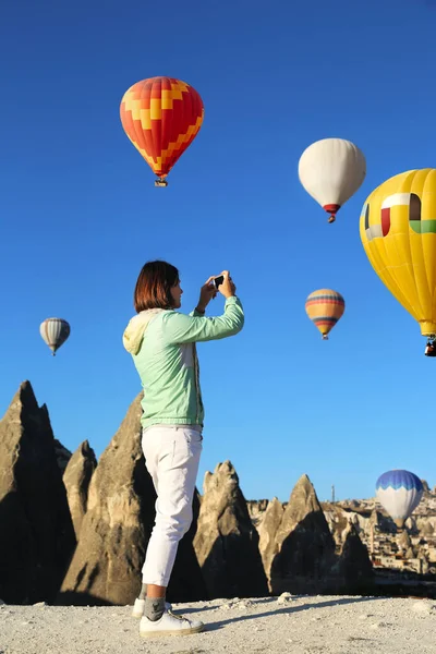 カッパドキアトルコで日の出と気球のフライトを楽しむ美しい幸せな女の子旅行者 自由生活 女性とともに写真自画撮り見熱気球 — ストック写真