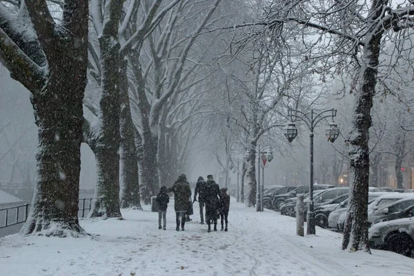 Piękne Ujęcie Ludzi Spacerujących Chodnikach Zostawiających Ślady Śniegu Podczas Opadów — Zdjęcie stockowe