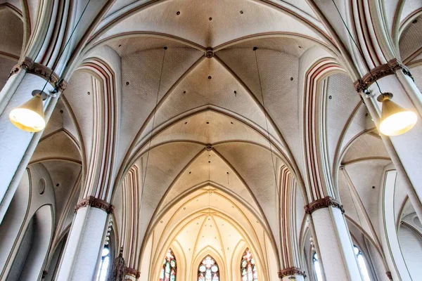 Baixo ângulo tiro do teto dentro de uma catedral histórica com lâmpadas penduradas — Fotografia de Stock