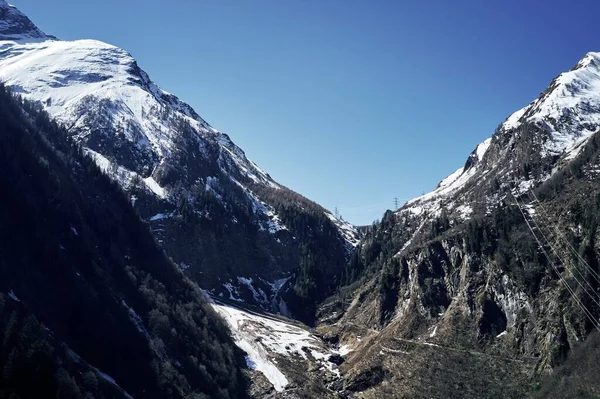Mooie lage hoek shot van een berg met sneeuw die de piek en de lucht in de achtergrond — Stockfoto