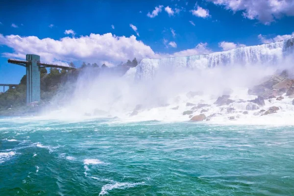 Piękny Wodospad Uderzający Fale Morskie Skałami Pod Pięknym Zachmurzonym Niebem — Zdjęcie stockowe