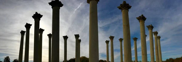 Bajo ángulo plano panorámico de columnas de hormigón bajo el cielo nublado impresionante — Foto de Stock