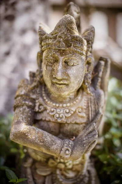 Tiro vertical de uma estátua no meio de um jardim — Fotografia de Stock