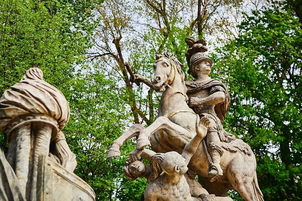 Baixo ângulo tiro de uma estátua de cavaleiro em um cavalo com as belas árvores verdes no fundo — Fotografia de Stock