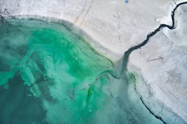 Hoge hoek opname van een grote scheur op de stenige kust naast het turquoise water — Stockfoto