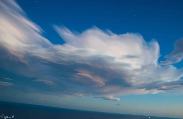Zapierające Dech Piersiach Niskokątne Ujęcie Puszystych Chmur Niebie Oceanu Poniżej — Zdjęcie stockowe