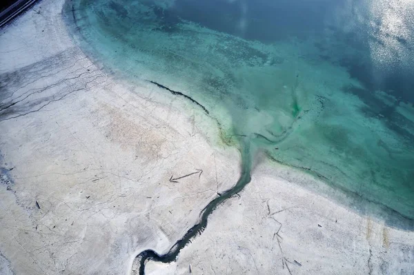 Hoge hoek opname van een grote scheur op de stenige kust naast het turquoise water — Stockfoto