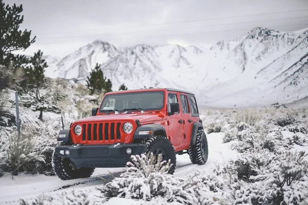 Krásný Záběr Červeného Vozidla Projíždějící Silnicí Pokrytou Sněhem Horách Kopci — Stock fotografie