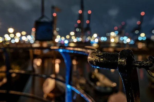 Close-up tiro de parte de um corrimão enferrujado em uma cidade à noite com luzes bokeh no fundo — Fotografia de Stock