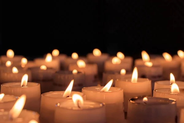 Closeup tiro de velas acesas para uma cerimônia religiosa em uma área escura — Fotografia de Stock