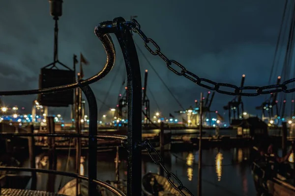 Detailní zábradlí a rezavý mokrý řetěz s řekou v průmyslovém městě v pozadí — Stock fotografie