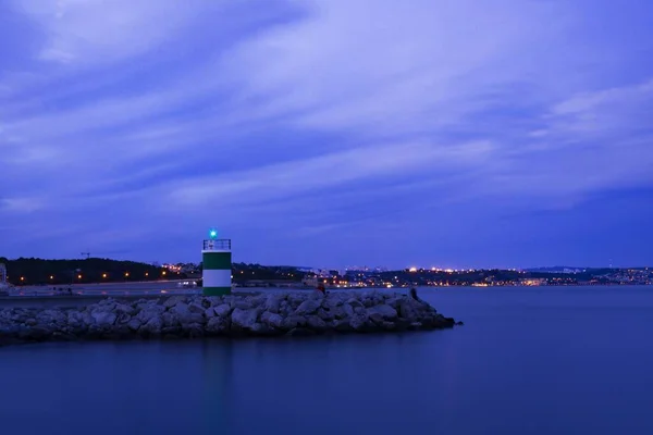 Belo Tiro Farol Perto Mar Com Edifícios Distância Sob Céu — Fotografia de Stock