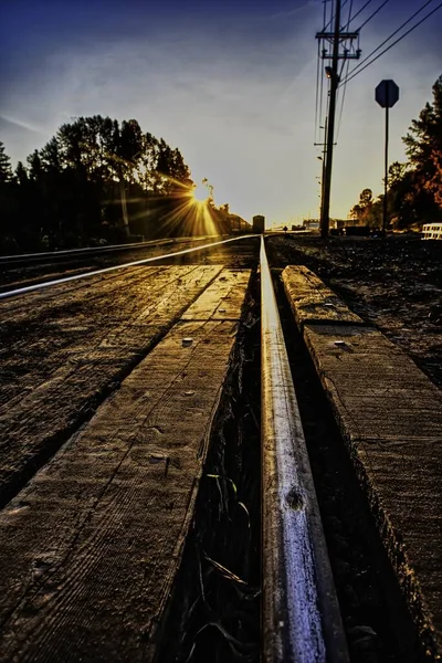 Tiro vertical de una vía de tren con la hermosa vista de la puesta de sol en el fondo —  Fotos de Stock