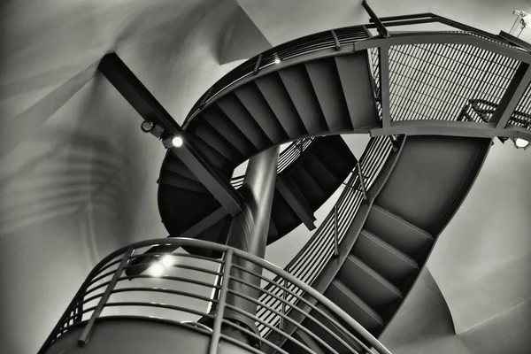 Escala de grises de bajo ángulo plano de una escalera redonda en el interior de un edificio moderno —  Fotos de Stock