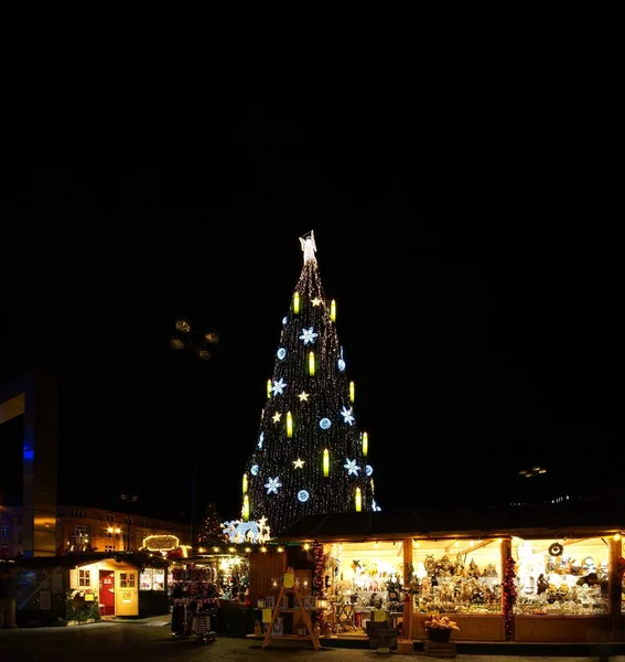 Vertikale Aufnahme eines Weihnachtsbaums inmitten eines Weihnachtsmarktes — Stockfoto